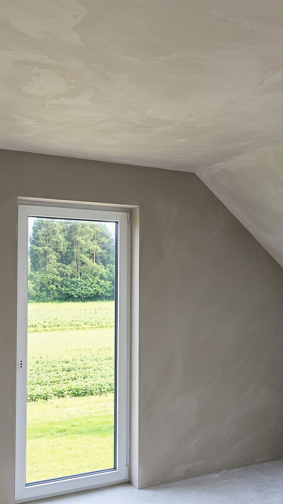 Strak gestucte zolderkamer met schuin plafond en een hoog raam
